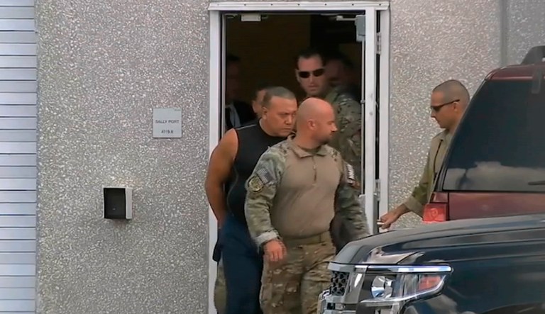 This frame grab from video provided by WPLG-TV shows FBI agents escorting Cesar Sayoc, in sleeveless shirt, in Miramar, Fla., on Friday, Oct. 26, 2018. 