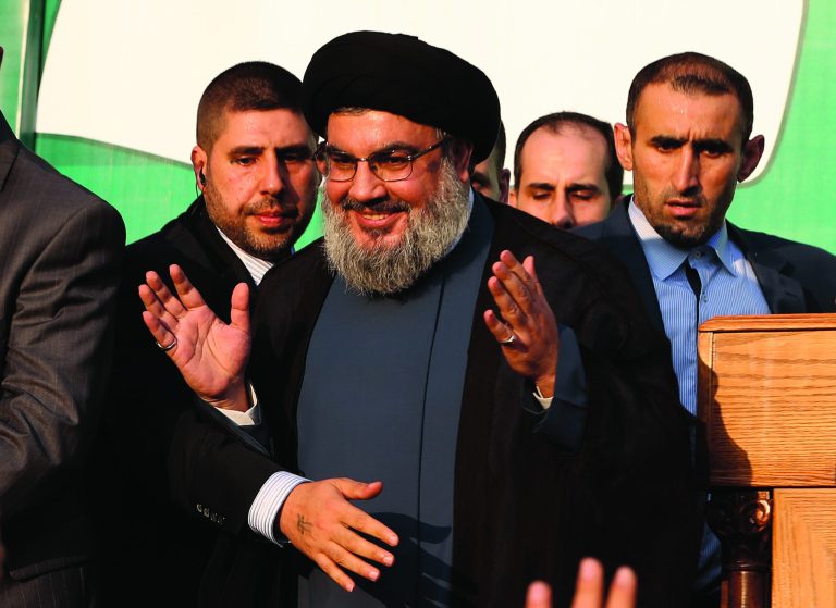 In this Monday, Sept. 17, 2012 photo, Hezbollah leader Sheik Hassan Nasrallah, center, waves to his supporters, in the southern suburb of Beirut, Lebanon. The leader of the Lebanese militant Hezbollah group has claimed responsibility for launching the drone aircraft that entered Israeli airspace earlier this week. The rare admission Thursday by Hassan Nasrallah raises regional tensions at a sensitive time when the group's backers, Syria and Iran, are under pressure. (AP Photo/Hussein Malla)