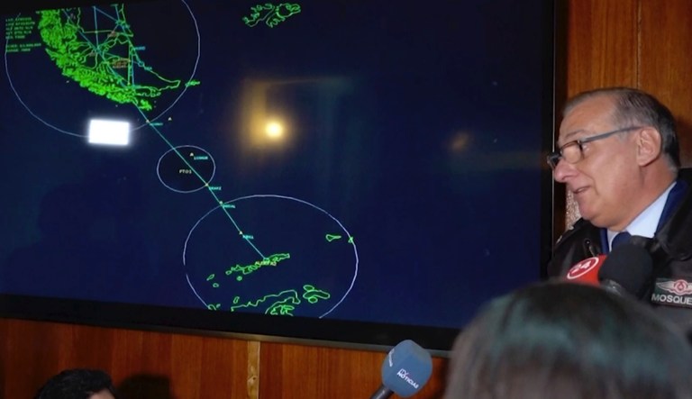 In this image made from video, Gen. Eduardo Mosqueira, right, of the Fourth Air Brigade speaks to the media next to a map of the area where the airplane is missing, in Punta Arenas, Chile, Monday, Dec. 9, 2019. Chile's air force lost radio contact with a transport plane carrying 38 people on a flight Monday evening to the country's base in Antarctica, and authorities indicated several hours later that they were not optimistic about the aircraft's fate. The military said earlier that it had declared an alert and activated search and rescue teams.