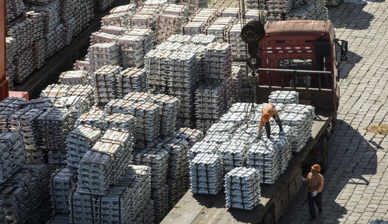 A worker stands on bundles of aluminum ingots on the back of a truck at a China National Materials Storage and Transportation Corp. stockyard in Wuxi, China, on Thursday, Aug. 23, 2018. The U.S. and China imposed fresh tariffs on each other's goods in the middle of trade talks aimed at averting the worsening conflict between the world's two biggest economies.