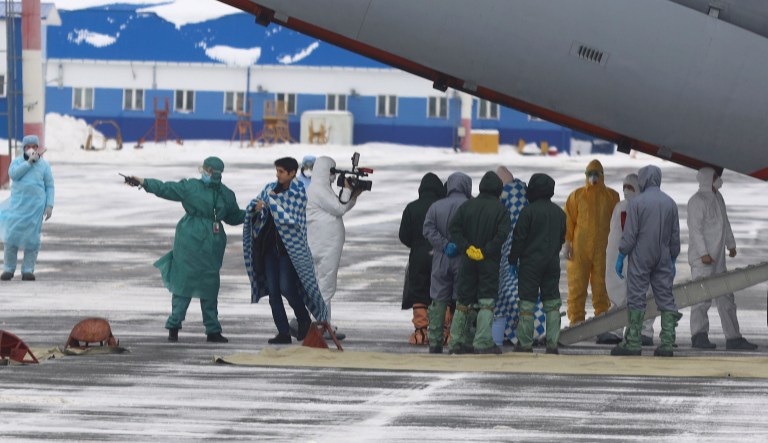 A group of medical personnel meet people, carried by a Russian military plane at an airport outside Tyumen, Russia, Wednesday, Feb. 5, 2020. Russia has evacuated 144 people, Russians and nationals of Belarus, Ukraine and Armenia, from the epicenter of the coronavirus outbreak in Wuhan, China, on Wednesday. All evacuees will be quarantined for two weeks in a sanatorium in the Tyumen region in western Siberia, government officials said. 