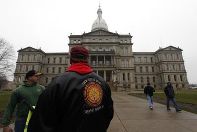 International Brotherhood of Electrical Workers members stand outside the capitol in Lansing, Mich., last week. (AP Photo/Paul Sancya)
