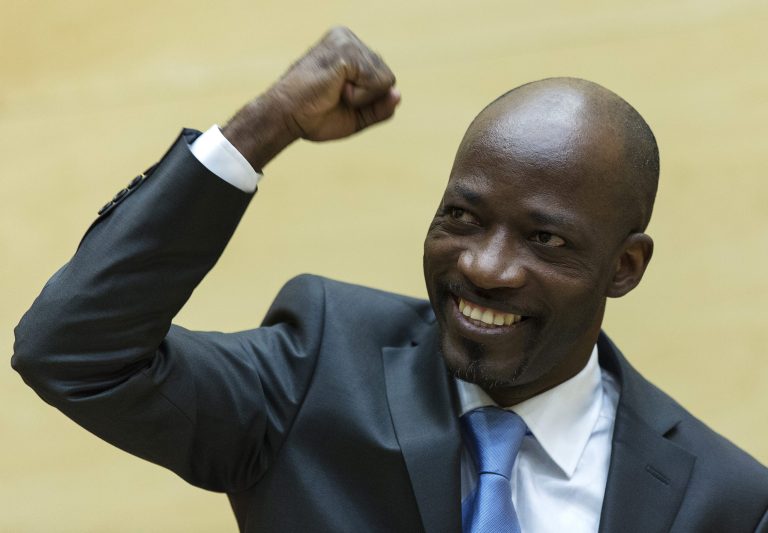 Charles Ble Goude gestures, as he enters the courtroom for his initial appearance at the International Criminal Court (ICC) in The Hague, Netherlands, Thursday, March 27, 2014. A former youth leader accused of involvement in murder, rapes and persecution during violence after 2010 Ivory Coast elections has appeared for the first time at the International Criminal Court. Goude looked confident, pumping his fist, waving and blowing a kiss to supporters in the public gallery at the brief hearing Thursday. (AP Photo/Michael Kooren, Pool)