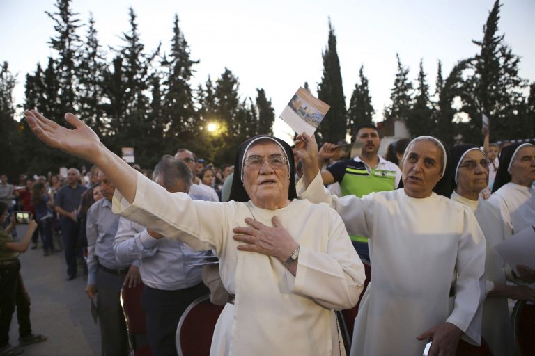 Iraqi Christian refugees attend an outdoor prayer service to mark a year since their displacement. (AP Photo/Raad Adayleh)