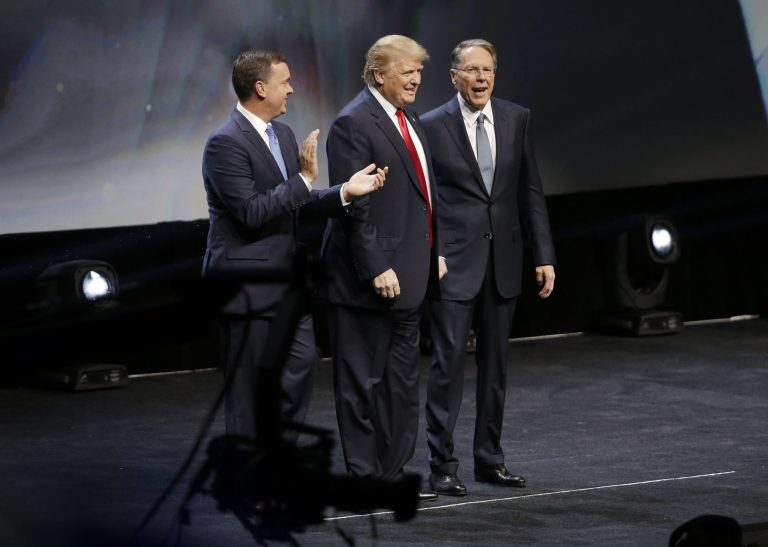 Republican presidential candidate Donald Trump is introduced by National Rifle Association executive director Chris W. Cox , left, and NRA executive vice president Wayne LaPierre, right, as Trump takes the stage to speak at the NRA convention Friday, May 20, 2016, in Louisville, Ky. (AP Photo/Mark Humphrey)