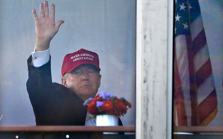 President Donald Trump waves to spectators as he watches the third round of the U.S. Women's Open Golf tournament from his observation booth, Saturday, July 15, 2017, in Bedminster, N.J. (AP Photo/Seth Wenig)