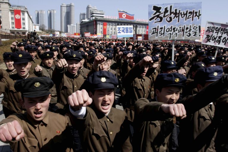 University students punch the air as they march through Kim Il Sung Square in downtown Pyongyang, North Korea, Friday, March 29, 2013. Tens of thousands of North Koreans turned out for the mass rally at the main square in Pyongyang in support of their leader Kim Jong Un's call to arms. Placards read: 