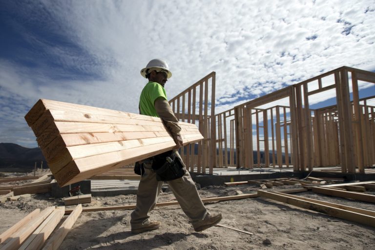   In this Friday, Nov. 16, 2012, photo, construction worker Miguel Fonseca carries lumber as he works on a house frame for a new home in Chula Vista, Calif. Confidence among U.S. homebuilders inched up in Novemeber to the highest level in more than six and a half years, as builders reported the best market for newly built homes since the housing boom.(AP Photo/Gregory Bull)  