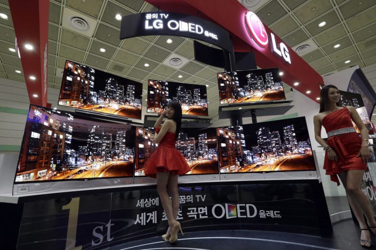 South Korean models pose with LG Electronics' organic light-emitting diode (OLED) television during World IT Show in Seoul, South Korea, Tuesday, May 21, 2013. South Korea's largest annual IT show open Tuesday for four days in Seoul and participate big companies such as Samsung Electronics Co. and LG Electronics Co. (AP Photo/Lee Jin-man)