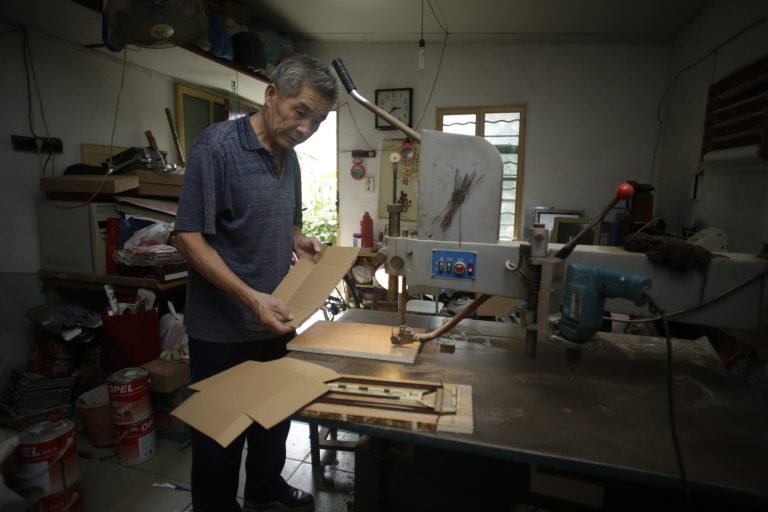 In this Sept. 9, 2013 photo, Dong Linhua, 59, works at his workshop in Shanghai. 
