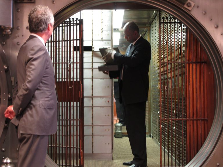 James B. Marshall stores the secret recipe for his Rivulet Artisan Pecan Liqueur in a bank vault Wednesday, July 9, 2014, in Louisville, Ky., as Mayor Greg Fischer looks on. The liqueur is made from brandy aged in bourbon barrels and blended through the secret recipe for its pecan flavor. (AP Photo/Bruce Schreiner)