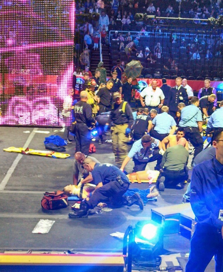In this photo provided by Rose Viveiros, first responders work at the center ring after a platform collapsed during an aerial hair-hanging stunt at the Ringling Brothers and Barnum and Bailey Circus, Sunday, May 4, 2014, in Providence, R.I. At least nine performers were seriously injured in the fall, including a dancer below, while an unknown number of others suffered minor injuries. (AP Photo/Rose Viveiros) MANDATORY CREDIT
