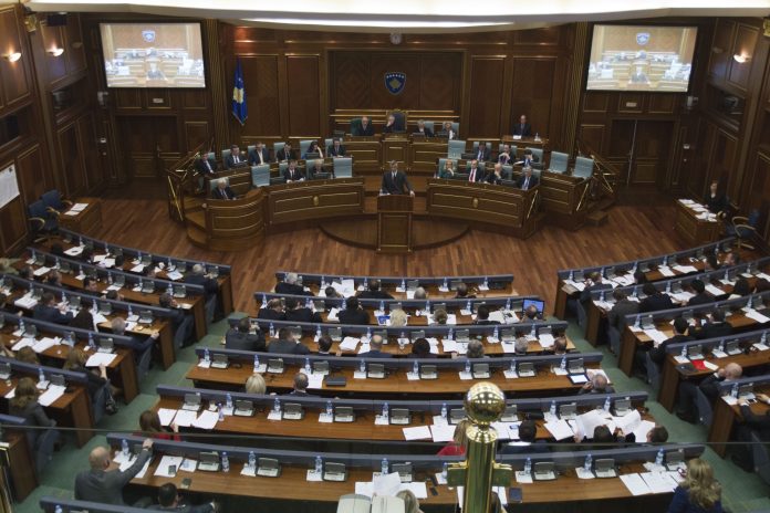Kosovo Prime Minister Hashim Thaci, standing centre, opens a  session in Kosovo's parliament in the capital Pristina on Wednesday April 23, 2014. Kosovo's parliament voted Wednesday on a law that will enable the creation of a special war crimes tribunal staffed by international judges and prosecutors that will try alleged crimes committed by former ethnic Albanian rebels during Kosovo's 1998-99 war for independence from Serbia.   (AP Photo/Visar Kryeziu)