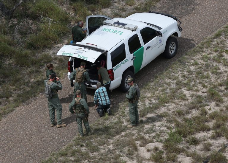 U.S. Border Patrol agents detain immigrants in brushland some 60 miles north of the U.S.-Mexico border in Brooks County on July 23, 2014 near Falfurrias, Texas. (Photo by John Moore/Getty images)