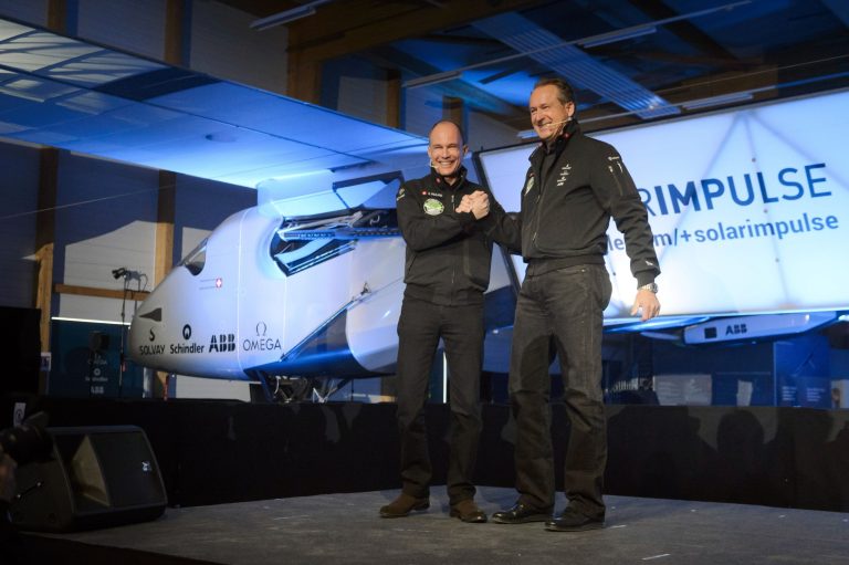 Solar Impulse's CEO and pilot Andre Borschberg, right, and Solar Impulse's founder, chairman and pilot Bertrand Piccard, left, shake hands in front of the new experimental aircraft 