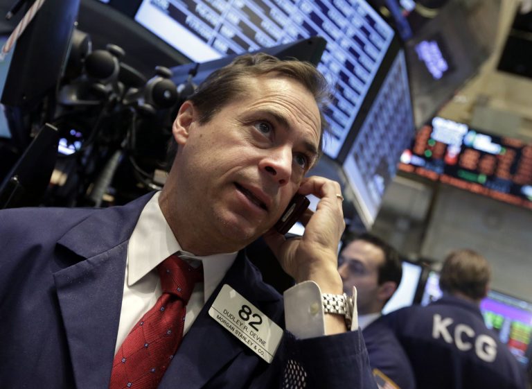 FILE - In this Wednesday, Feb. 19, 2014, file photo, trader Dudley Devine uses his mobile phone as he works on the floor of the New York Stock Exchange. A contraction in Chinese manufacturing and the possibility of higher U.S. interest rates dragged global stock markets lower Thursday Feb. 20, 2014. (AP Photo/Richard Drew)