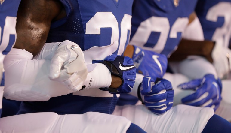 Members of the Indianapolis Colts lock arms as they take a knee during the Nation Anthem before an NFL football game against the Cleveland Browns in Indianapolis, Sunday, Sept. 24, 2017. (AP Photo/Darron Cummings)