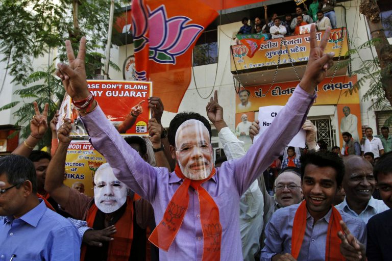   Indian supporters of Bharatiya Janata Party (BJP) wear masks of Gujarat chief minister Narendra Modi as they celebrate to early reports that their party is leading in the Gujarat assembly elections in Ahmadabad, India, Thursday, Dec. 20, 2012. The votes are currently being counted with the final results expected later in the day. (AP Photo/Ajit Solanki)  