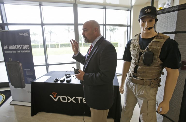 John Hall, president and CEO of Voxtec International, demonstrates his company's real-time translation system, during a media opportunity at the U.S. Southern Command headquarters in Doral, Fla. on Wednesday, Sept. 3, 2014. Southcom is showing off a variety of new equipment intended to improve communications during disaster relief and humanitarian assistance missions. Southcom oversees U.S. military operations in Central and South America and the Caribbean. (AP Photo/Wilfredo Lee)