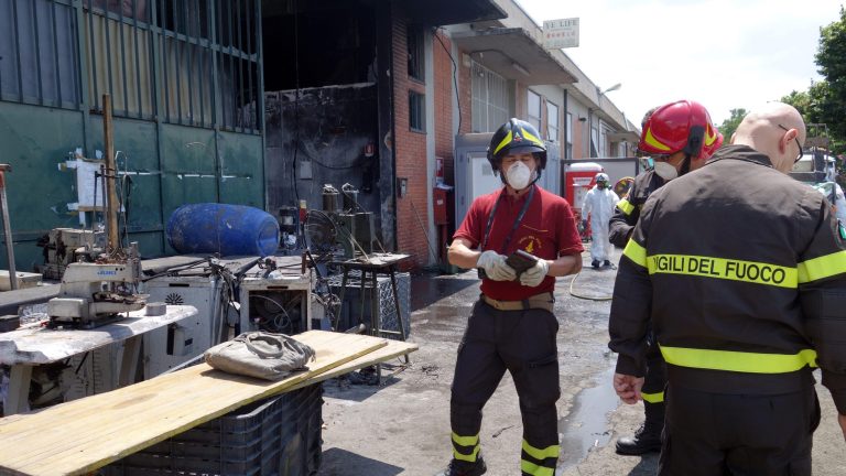 In this June 20, 2014 photo, firemen inspect the burned Teresa Moda garment factory in Prato, Italy. The fire that destroyed the Teresa Moda factory on Dec. 1, 2013, was the deadliest in living memory. It exposed the true cost of cheap clothes, laying bare the consequences of years of failed law enforcement and the pursuit of profit over safety. (AP Photo/Erika Kinetz)