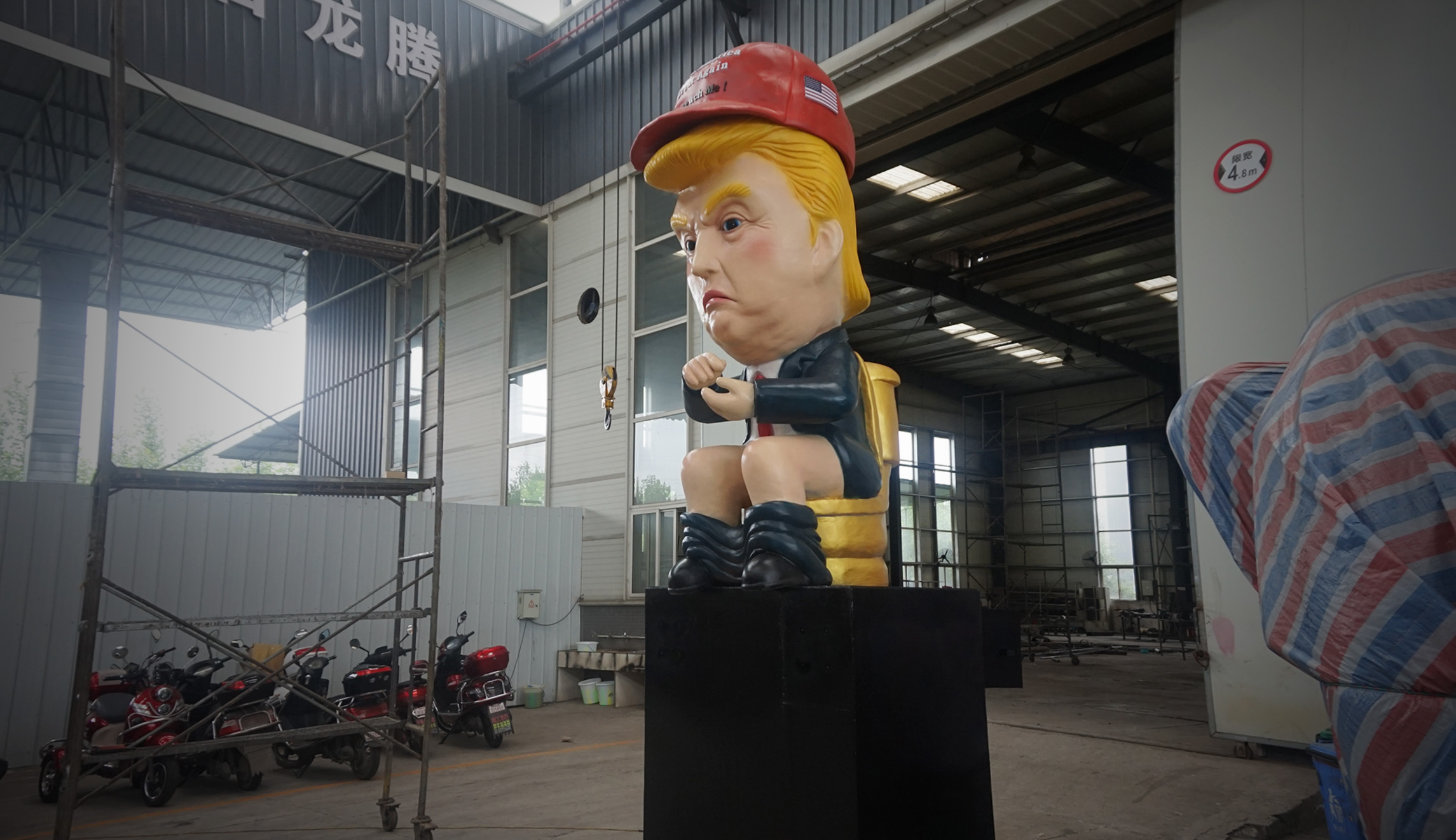 "Dumping Trump," a robot depicting President Trump seated on a toilet, is seen in a building.