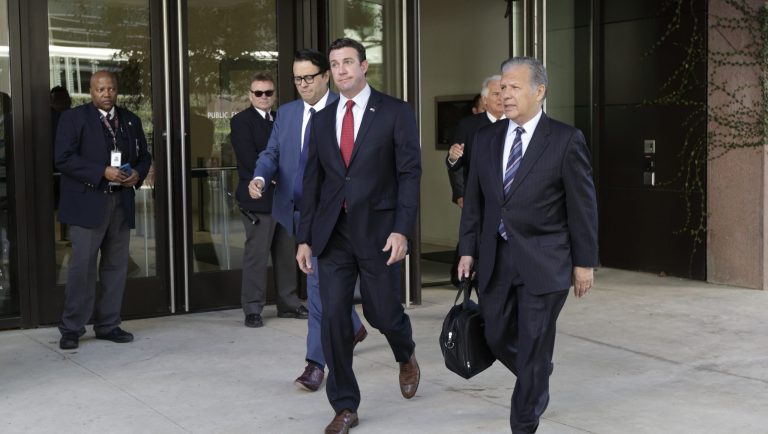 Republican Rep. Duncan Hunter, center, wearing red tie, leaves court Monday, Dec. 3, 2018, in San Diego. The indicted congressman is returned to court Monday for the first time since being re-elected to a sixth term amid corruption charges. 