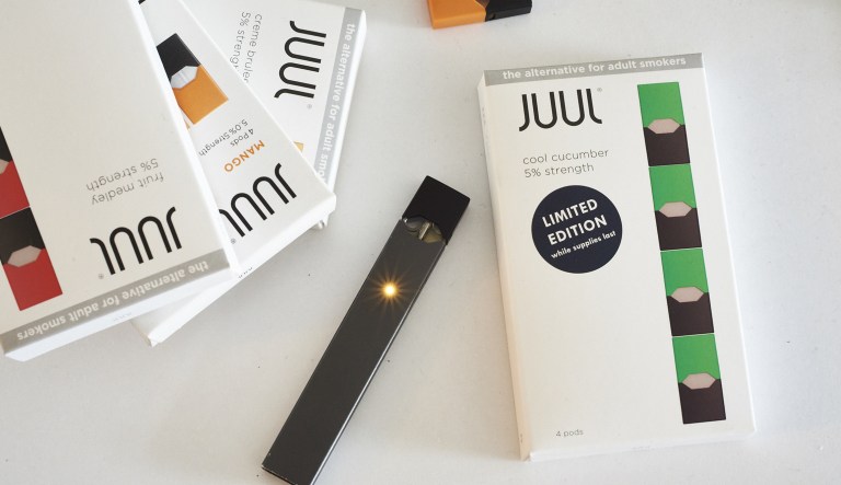 A Juul Labs Inc. e-cigarette and flavored pods are arranged for a photograph in the Brooklyn Borough of New York, U.S., on Sunday July 8, 2018. Juul Labs, the maker of the popular e-cigarette brand that has recently come under fire from health officials over its popularity with young adults, plans to introduce a line of lower-nicotine pods. The company will begin to sell pods with a 3-percent nicotine concentration in its mint and Virginia tobacco flavors later this year, according to a statement Thursday.