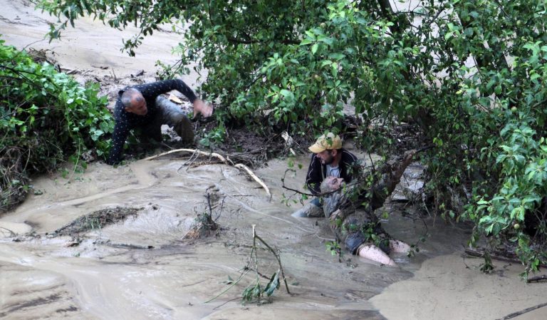 People try to save a man from the floods in the Black sea town of Varna, Bulgaria, Thursday, June 19, 2014. Two people and a child are reported dead and four more are missing. Torrential rain caused severe flooding in Bulgaria, sweeping away cars, reducing scores of homes to rubble, the country's civil defense authority said. (AP Photo/ImpactPressGroup)