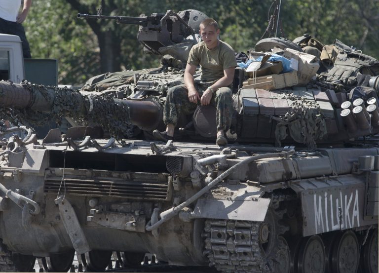 A Ukrainian government army soldier rests on his tank at a block-post in the village of Debaltseve, eastern Ukraine Friday, Aug. 1, 2014. With the sound of artillery blasts at a distance, dozens of international investigators arrived Friday at the eastern Ukraine site where Malaysia Airlines Flight 17 crashed and began a painstaking search for the remains of as many as 80 victims. (AP Photo/Dmitry Lovetsky)
