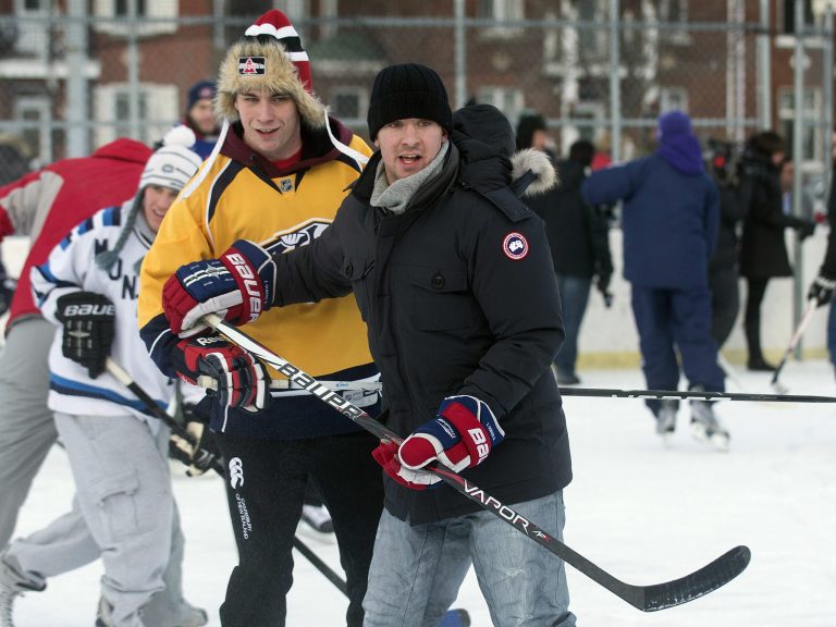   Montreal Canadiens defenseman Josh Gorges, right, watches the play during a game of pick-up hockey in Montreal, Wednesday, Dec. 26, 2012. Gorges used Twitter to organize a Boxing Day outdoor hockey game with fans at a neighborhood rink in Montreal. (AP Photo/The Canadian Press, Graham Hughes)  