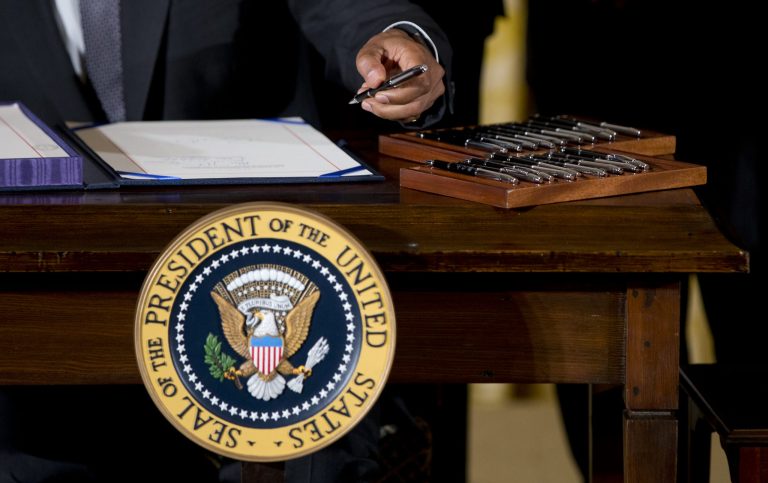 President Obama signing a bill. Voters don't like his plan to use his pen to OK executive orders. (AP Photo/Carolyn Kaster)