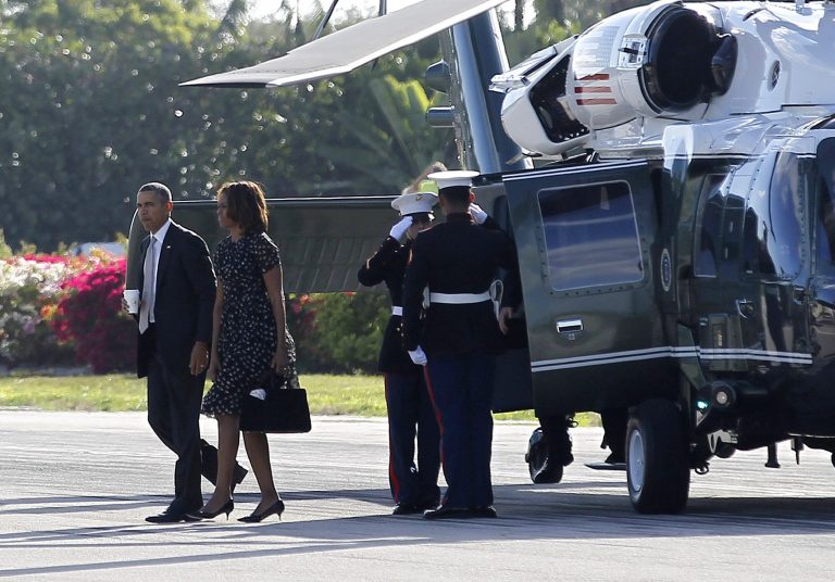 President Barack Obama and first lady Michelle Obama walk across the tarmac following their arrival on Marine One helicopter at Ocean Reef Club in Key Largo, Fla., to begin their weekend vacation. White House spokesman Josh Earnest defended Obama's trip to Key Largo, despite the ongoing crisis in Ukraine, arguing Obama would be able to monitor events from Florida. (AP Photo/Pablo Martinez Monsivais)