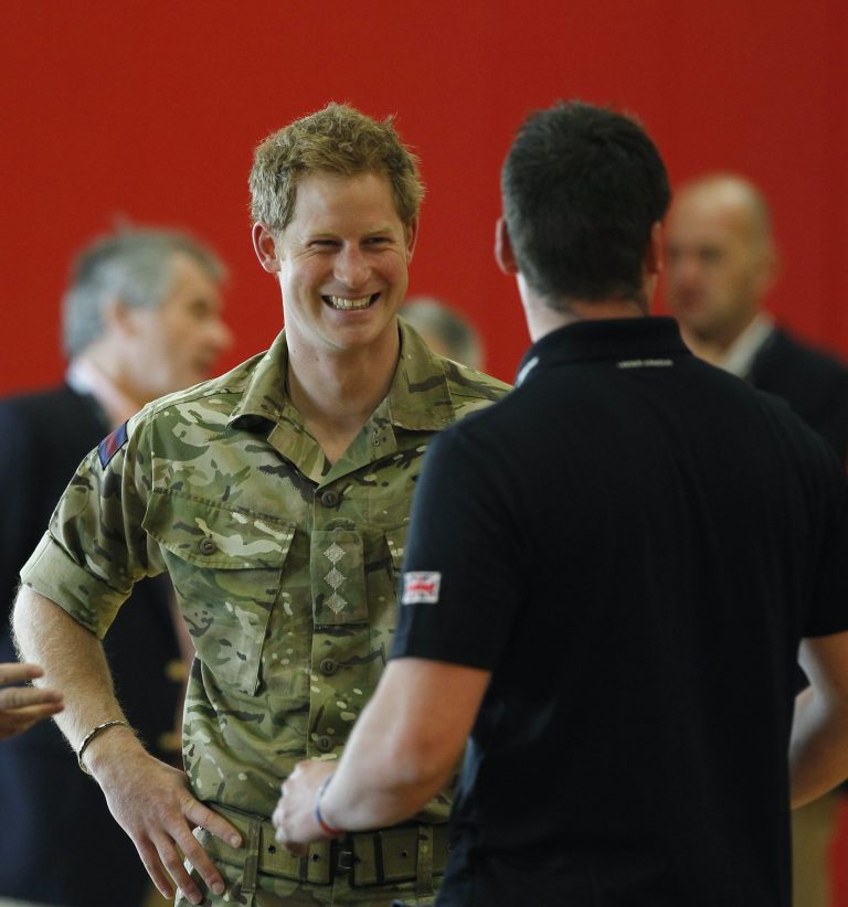 Britain's Prince Harry talks with members of the British Warrior Games Team who relaxed in a gymnasium before the opening of the 2013 Warrior Games, at the U.S. Olympic Training Center, in Colorado Springs, Colo., Saturday May 11, 2013. (AP Photo/Brennan Linsley, Pool)