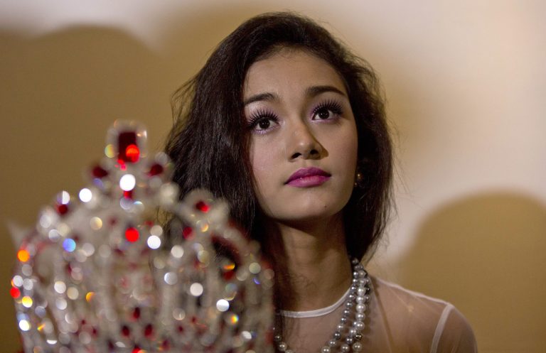 May Myat Noe, Myanmar's first international beauty queen, winner of the 2014 Miss Asia Pacific World, sits with her crown that she allegedly ran away with, during a press conference in Yangon, Myanmar Tuesday, Sept. 2, 2014. The dethroned beauty queen from Myanmar said she won't return her $100,000 worth crown until the pageant's organizers apologize for calling her a liar and a thief. (AP Photo/Gemunu Amarasinghe)