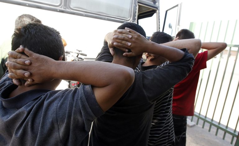 FILE - In this Aug. 9, 2012 file photo, newly arrived people who were caught in Arizona by the U.S. Border Patrol, are initially processed at Tucson Sector U.S. Border Patrol Headquarters in Tucson, Ariz.  A major U.S. effort to discourage repeated attempts by immigrants to enter the country illegally by flying and busing them into Mexico hundreds of miles away from where they were caught has been sharply scaled back after producing relatively modest gains. (AP Photo/Ross D. Franklin, file)