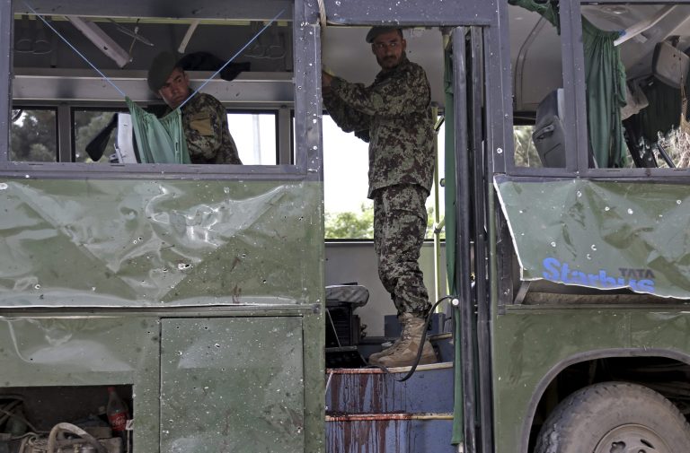 Afghan National Army (ANA) soldiers prepare to remove a destroyed military bus at the site of a suicide attack in Kabul, Afghanistan, Wednesday, June 2, 2014. A suicide bomber attacked the air force bus in Afghanistan's capital early Wednesday, killing at least four people, security officials said. (AP Photo/Rahmat Gul)