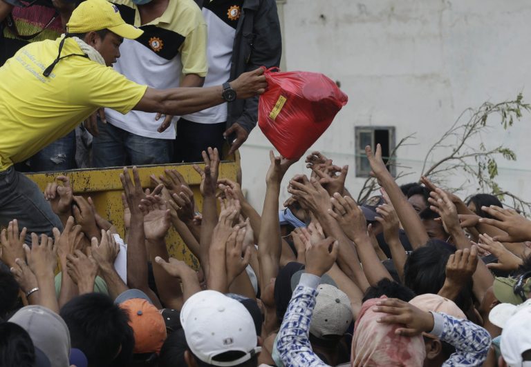   Residents affected by typhoon Bopha crowd as relief goods are distributed at New Bataan township, Compostela Valley in southern Philippines Sunday Dec. 9, 2012. The number of missing in the wake of the typhoon that devastated parts of the southern Philippines has jumped to nearly 900 after families and fishing companies reported losing contact with more than 300 fishermen in the South China Sea and Pacific Ocean, officials said Sunday. (AP Photo/Bullit Marquez)  