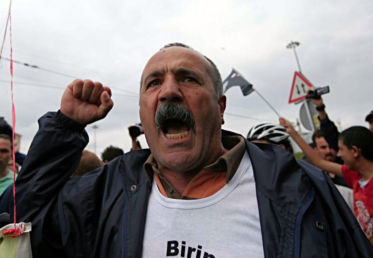 A man shouts as plain clothes security members try to detain a person who was reading as security close the city's landmark Taksim Square and Gezi Park on the first anniversary of last year's protests in Istanbul, Turkey, Saturday, May 31, 2014. A government backed redevelopment plan for Gezi Park in Istanbul sparked anger and morphed into nationwide anti-government protests in June, leaving eight people dead and thousands other injured.(AP Photo/Emrah Gurel)