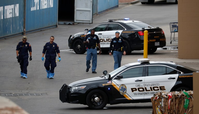 Police officers walk behind a Walmart at the scene of a mass shooting at a shopping complex Tuesday, Aug. 6, 2019, in El Paso, Texas.