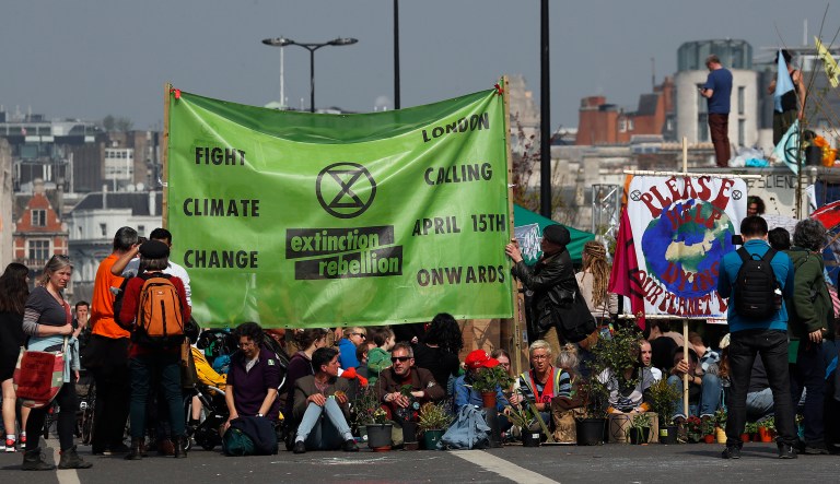 Protestors sit on the road of the blocked Waterloo Bridge in London, Wednesday, April 17, 2019. The group Extinction Rebellion is calling for a week of civil disobedience against what it says is the failure to tackle the causes of climate change.