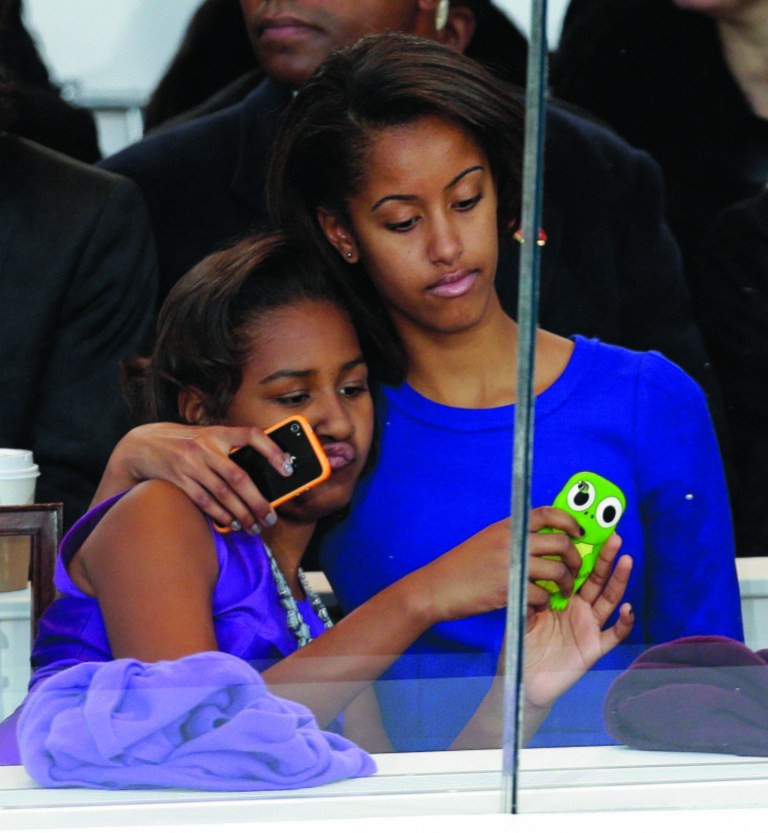 Malia Obama, right, and Sasha Obama look on from the presidential box during the Inaugural parade, Monday, Jan. 21, 2013, in Washington. Thousands marched during the 57th Presidential Inauguration parade after the ceremonial swearing-in of President Barack Obama. (AP Photo/Gerald Herbert)
