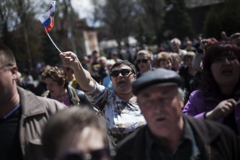 A Ukrainian woman waves a Russian flag while chanting pro Russian slogans during a pro Russia rally in Khartsyrsk, Ukraine, Monday, April 21, 2014. A group of foreign reporters has been captured by pro-Russian insurgents in an east Ukrainian city, but were later released. One Belarusian and two Italian journalists were detained by gunmen in the city of Slovyansk, which has been occupied by pro-Russian forces for more than a week. Slovyansk is part of many towns in the Russian-speaking region where insurgents are demanding greater ties with Russia. (AP Photo/Manu Brabo)
