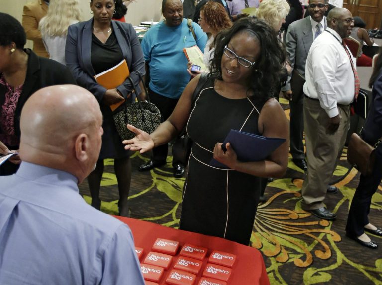 In this Thursday, June 12, 2014 photo, Marsha Lawson talks with a representative from CVS at the Cleveland Career Fair in Independence, Ohio. Optimism among chief executives of large U.S. companies has reached a two-year high, driven by greater optimism about hiring and sales. (AP Photo/Tony Dejak)