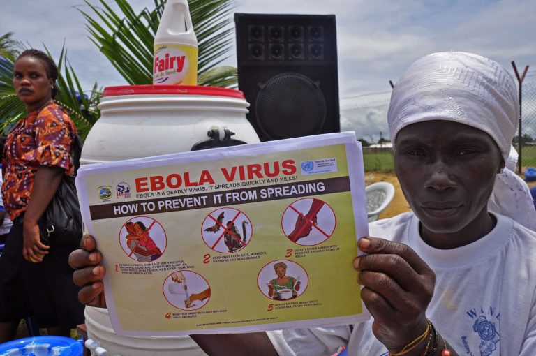A Liberian woman holds up a pamphlet with guidance on how to prevent the Ebola virus from spreading, in the city of Monrovia, Liberia, Thursday, Aug. 14, 2014. Liberian officials faced a difficult choice Thursday: deciding which handful of Ebola patients will receive an experimental drug that could prove life-saving, ineffective or even harmful. (AP Photo/Abbas Dulleh)