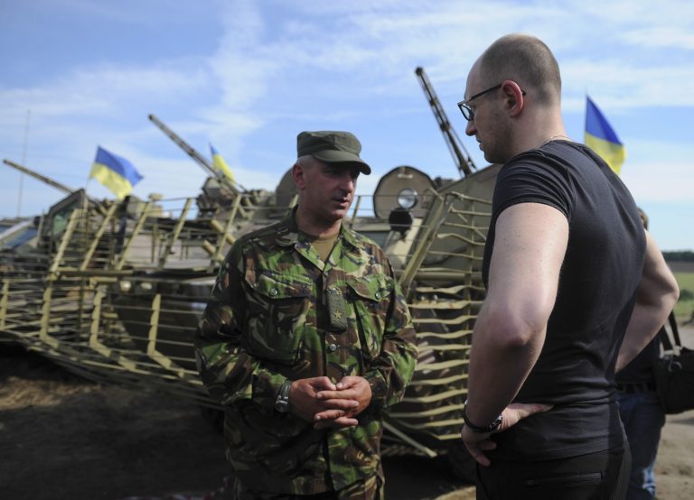 Ukrainian Prime Minister Arseniy Yatsenyuk, right, talks to an officer during inspection of a Ukrainian Army position outside the eastern town of Slovyansk, Ukraine, Wednesday, July 16, 2014.  Yatsenyuk hopes to restore the infrastructure in Donetsk and Lugansk regions from state budget, thanks to private investors and international aid, he said during his visit to the Slovyansk on Wednesday. (AP Photo/Andrew Kravchenko, Pool)
