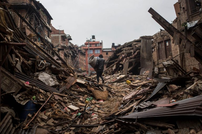 A man carries bedding through a destroyed street in Bhaktapur on April 30, 2015 in Kathmandu, Nepal. A major 7.8 earthquake hit Kathmandu mid-day on Saturday, and was followed by multiple aftershocks that triggered avalanches on Mt. Everest that buried mountain climbers in their base camps. (Getty Images)