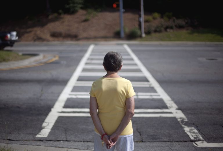 A resident of the Marion Apartments at 760 Sidney Marcus Boulevard waits for the light to change to cross the street outside the building Wednesday, June 15, 2011 in Atlanta. (AP Photo/David Goldman)