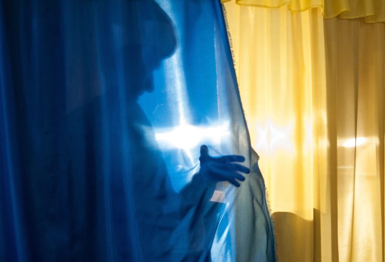 A local resident casts a shadow on leaving a booth to cast her ballot at a polling station in Luhansk, Ukraine, on Sunday May 11, 2014. Residents of two restive regions in eastern Ukraine cast ballots Sunday in referendums, which seek approval for declaring sovereign people's republics in the Donetsk and Luhansk regions. (AP Photo/Evgeniy Maloletka)