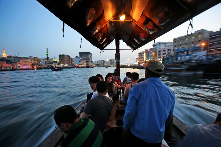 In this Monday, May 26, 2014 photo, tourists and residents cross the creek waters which cuts through the heart of the city, on a traditional abra, or taxi boat, in Dubai, United Arab Emirates. The 14 kilometer (9 mile) Khor Dubai in Arabic or Dubai Creek, is a natural seawater inlet of the Persian Gulf located in the heart of city that runs South to East and ends at Ras Al-Khor wildlife Sanctuary. The creek that divides the city into two parts, Bur Dubai and Deira, has played a major historical role in the economic development of the region. (AP Photo/Kamran Jebreili)