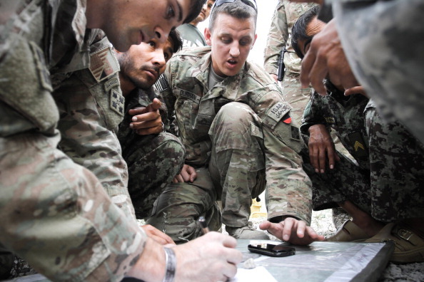 PECH VALLEY, AFGHANISTAN - JUNE 23:  US soldiers from 2-12 Infantry Regiment out of Colorado Springs instructs an Afghan artilleryman how to correctly aim a canon down the Pech valley on June 23, 2012 in the Pech Valley, Afghanistan. (Photo by John Cantlie/Getty Images)